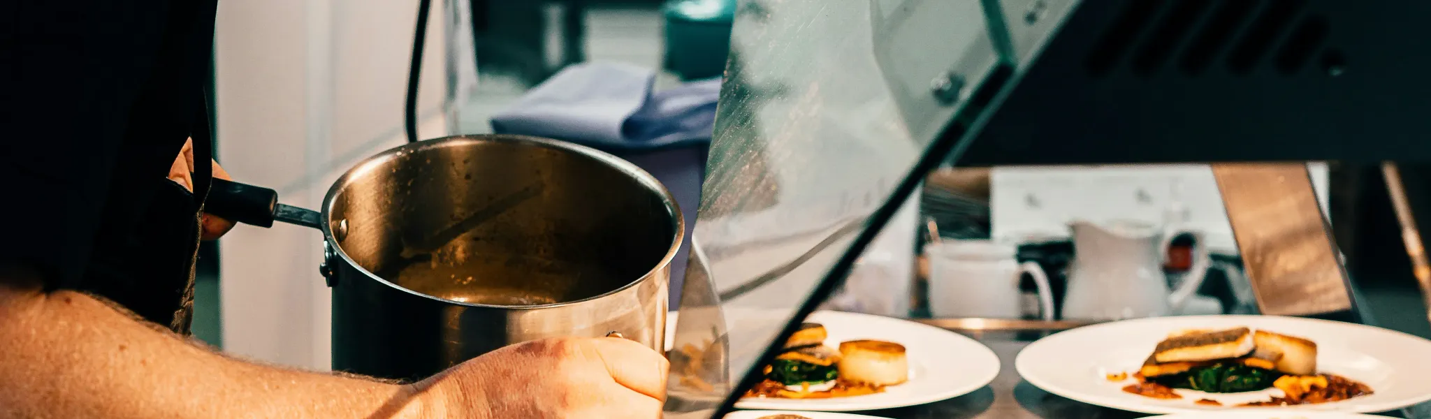 Chef using digital thermometer to check food temperature in professional kitchen