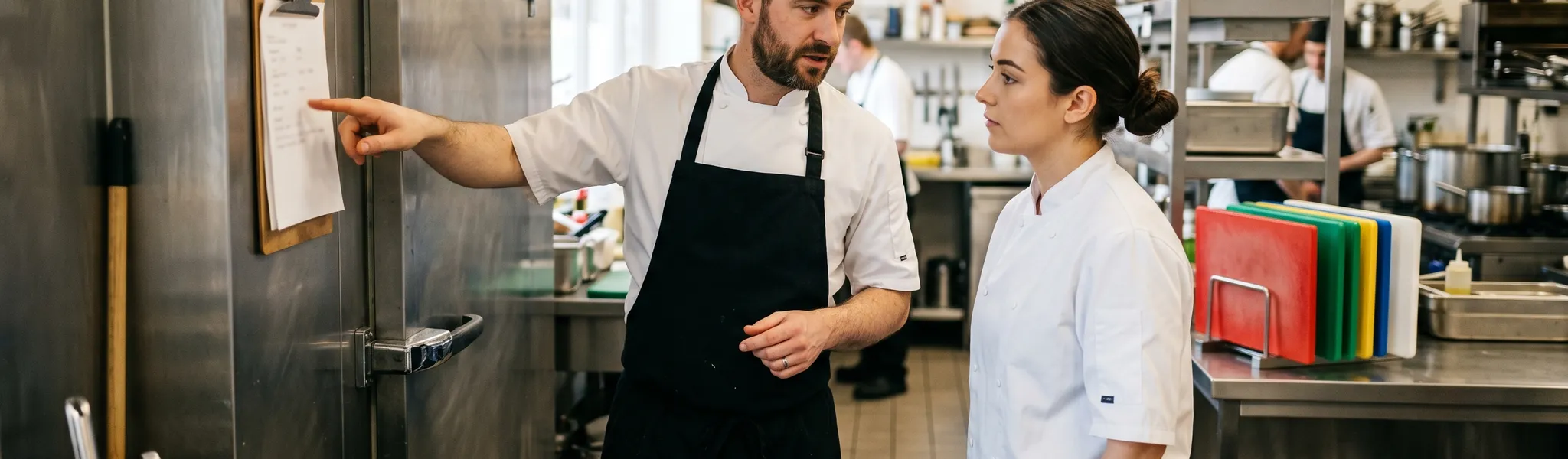 Chef reviewing HACCP food safety documentation in a commercial kitchen